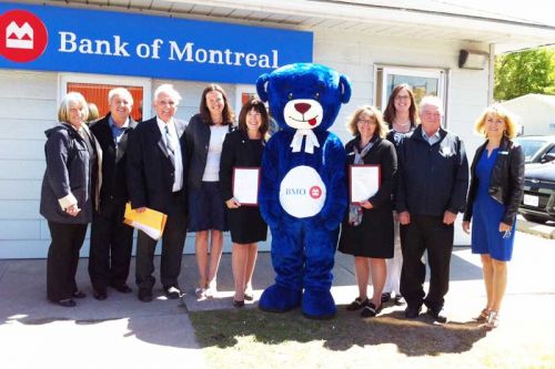 (l-r) Chris Langevin, Bill Cox, Fred Perry, Jen Baker, Sandra Henderson, BMO the Bear, Danielle Williams, Cythia Surette, Henry Hogg, and Esther Denczak at BMO Northbrook's special 50th year celebrations that took place at the branch on May 20.